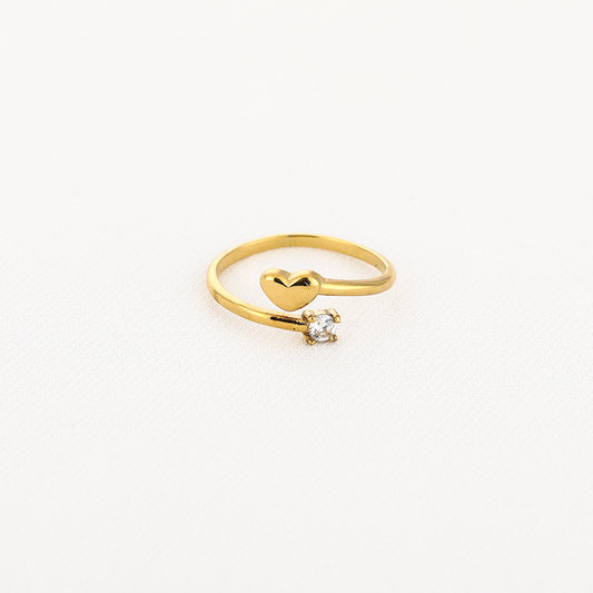 Goudkleurige open ring met hartje en sprankelend steentje
